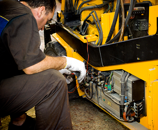 A mechanic examining a forklift